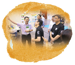 本署同事向發展局常任秘書長(工務)韋志成先生(中)解釋展板內容