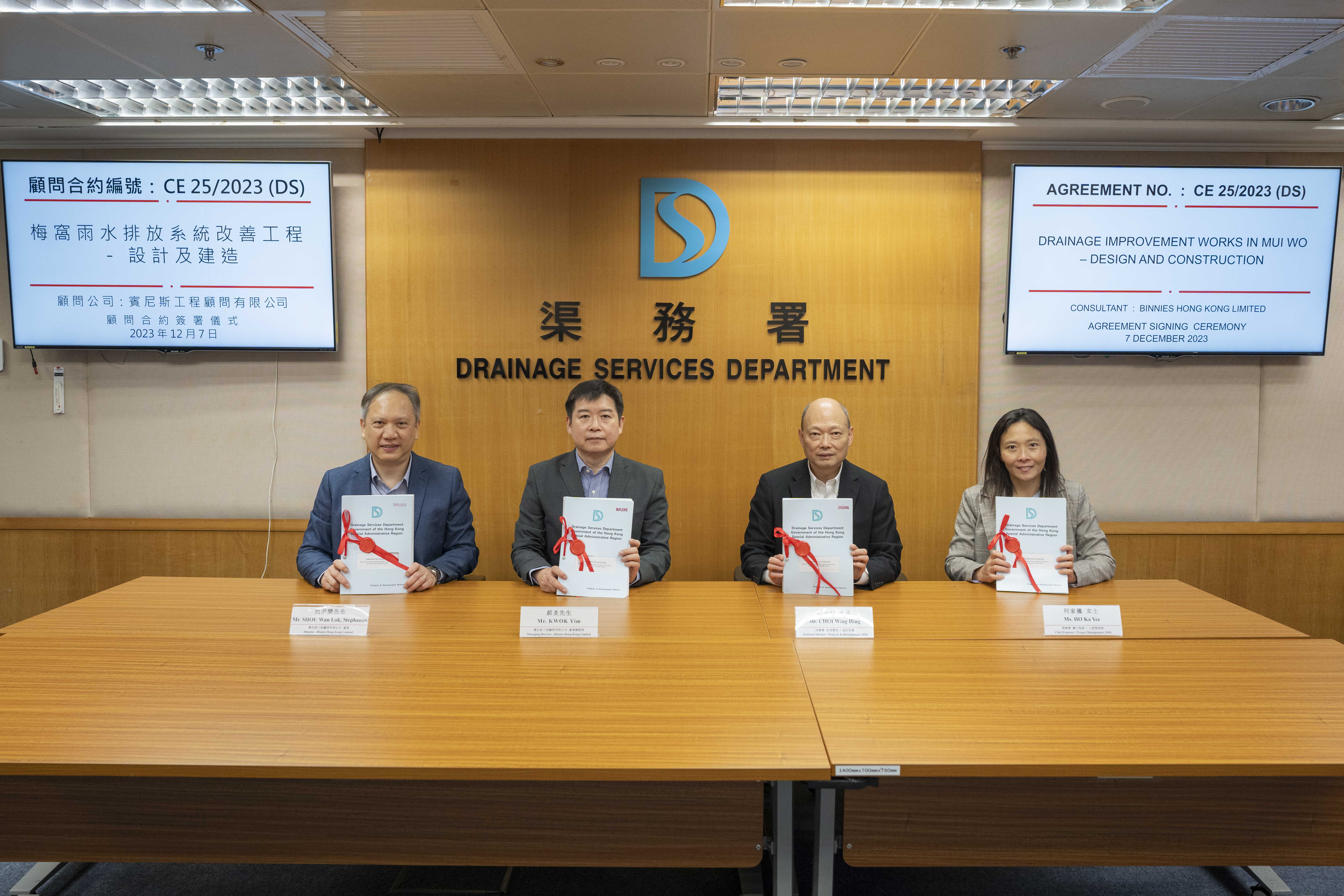 渠務署助理署長/設計拓展蔡榮興先生（右二）及總工程師/工程管理何家儀女士（右一）與賓尼斯工程顧問有限公司董事總經理郝炎先生（左二）及董事仇尹樂先生（左一）出席顧問合約簽署儀式。  