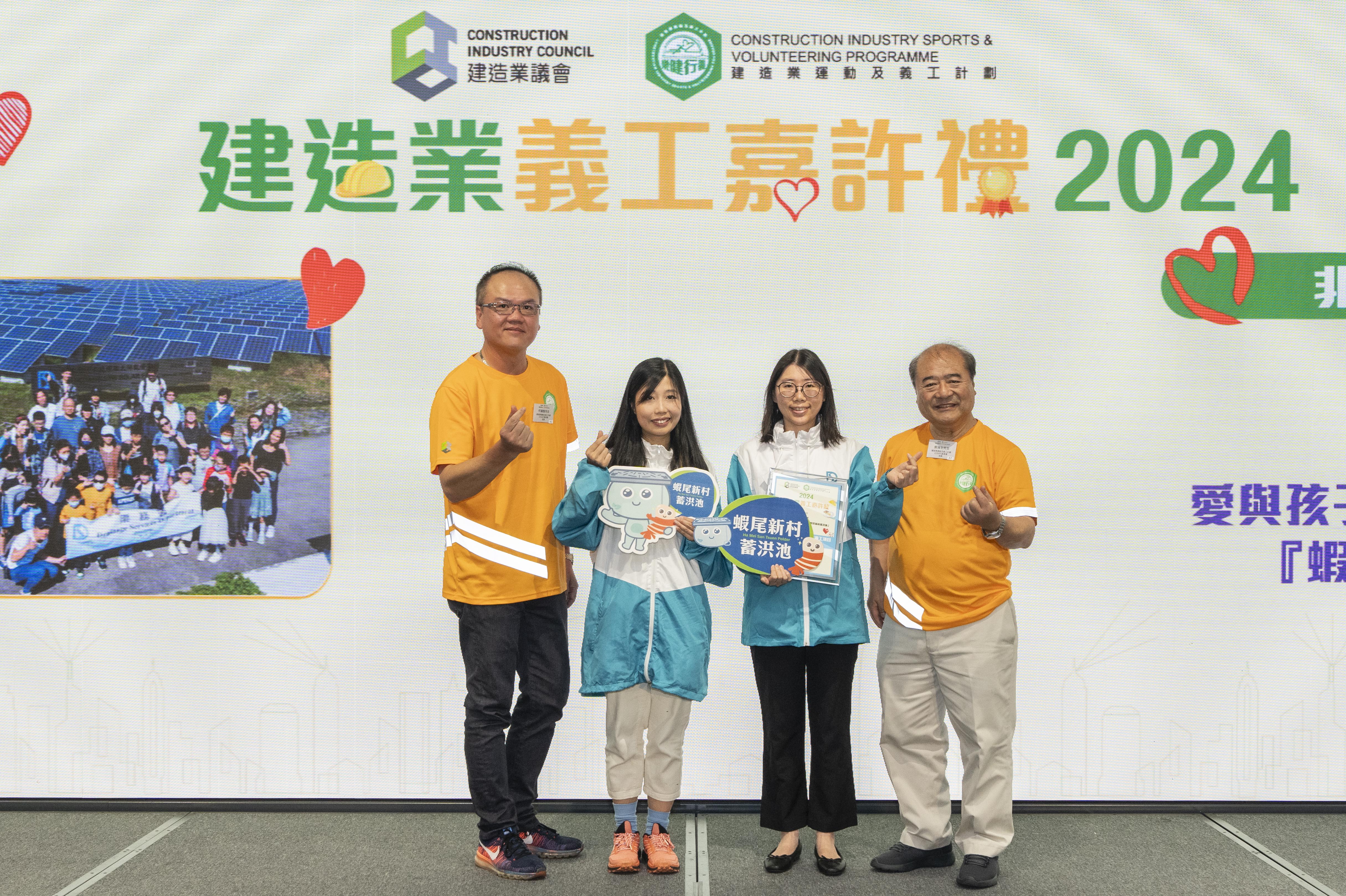 新界北渠務部代表封雪女士（右二）及余秋婷女士（左二）接受非凡建造業義工項目（優異獎）。