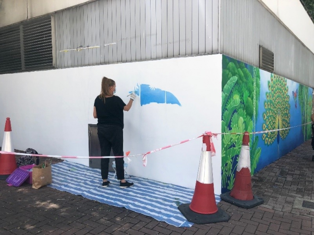 Finnish artist Riitta Kuisma painting the work