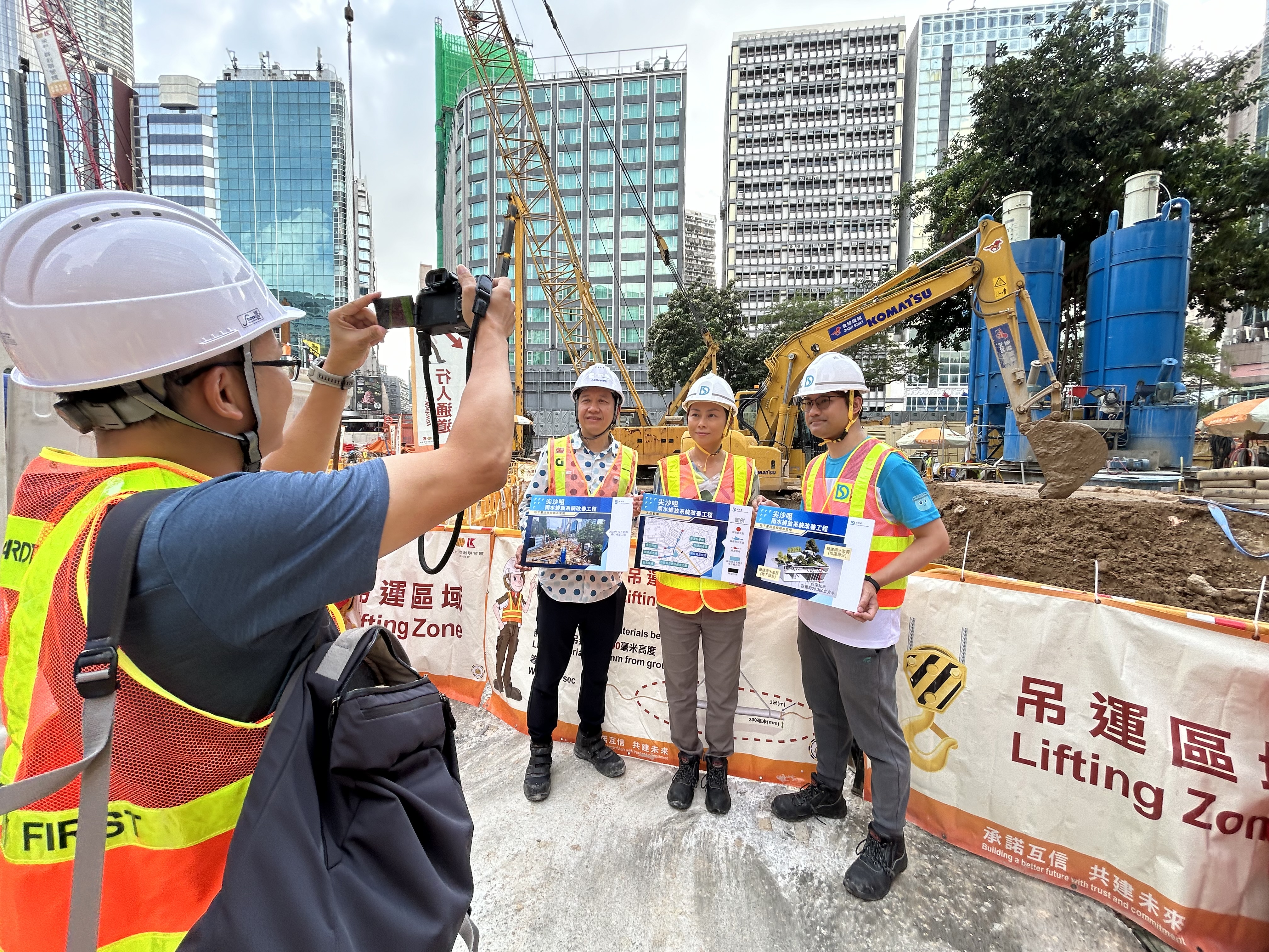 DSD Senior Engineer, Ms Karen CHAN Ka-yan (middle), and DSD Engineer, Mr Jackel TANG Tze-fai (first right), toured around the works site of the Drainage Improvement Works in Tsim Sha Tsui with the reporters