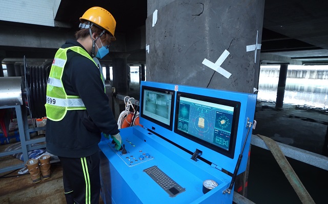 渠务署积极运用新科技提升排水系统保养及维修工作的效率和安全。图示工作人员透过控制台遥距操控河道清淤机械人「深水清」。