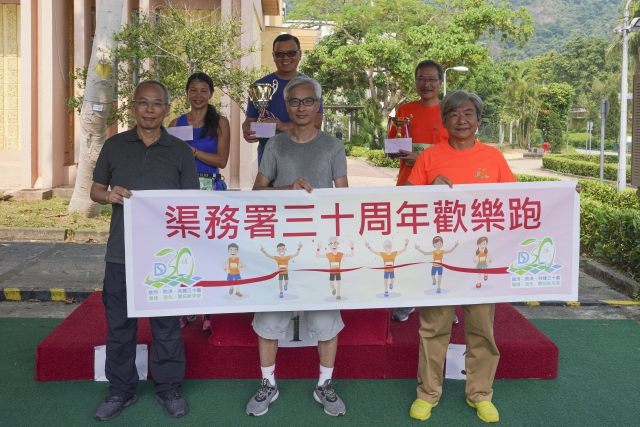 Group photo of Director of Drainage Services, Mr LO Kwok-wah (middle of front row), Deputy Director of Drainage Services, Mr MAK Ka-wai (right of front row) and Assistant Director／Electrical and Mechanical, Mr PAK Kan-ming (left of front row), and the winners of the 5km Senior Race