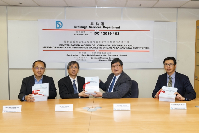 渠務署助理署長／設計拓展黃緒勤先生（右二）及總工程師/排水工程王協力先生（右一）與建信建築有限公司總經理何志剛先生（左二）及工程經理黃浩然先生（左一）進行合約簽署儀式