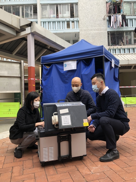 渠务署总工程师黎玮筠女士（左）向环境局局长黄锦星先生（中）解释收集污水样本的过程