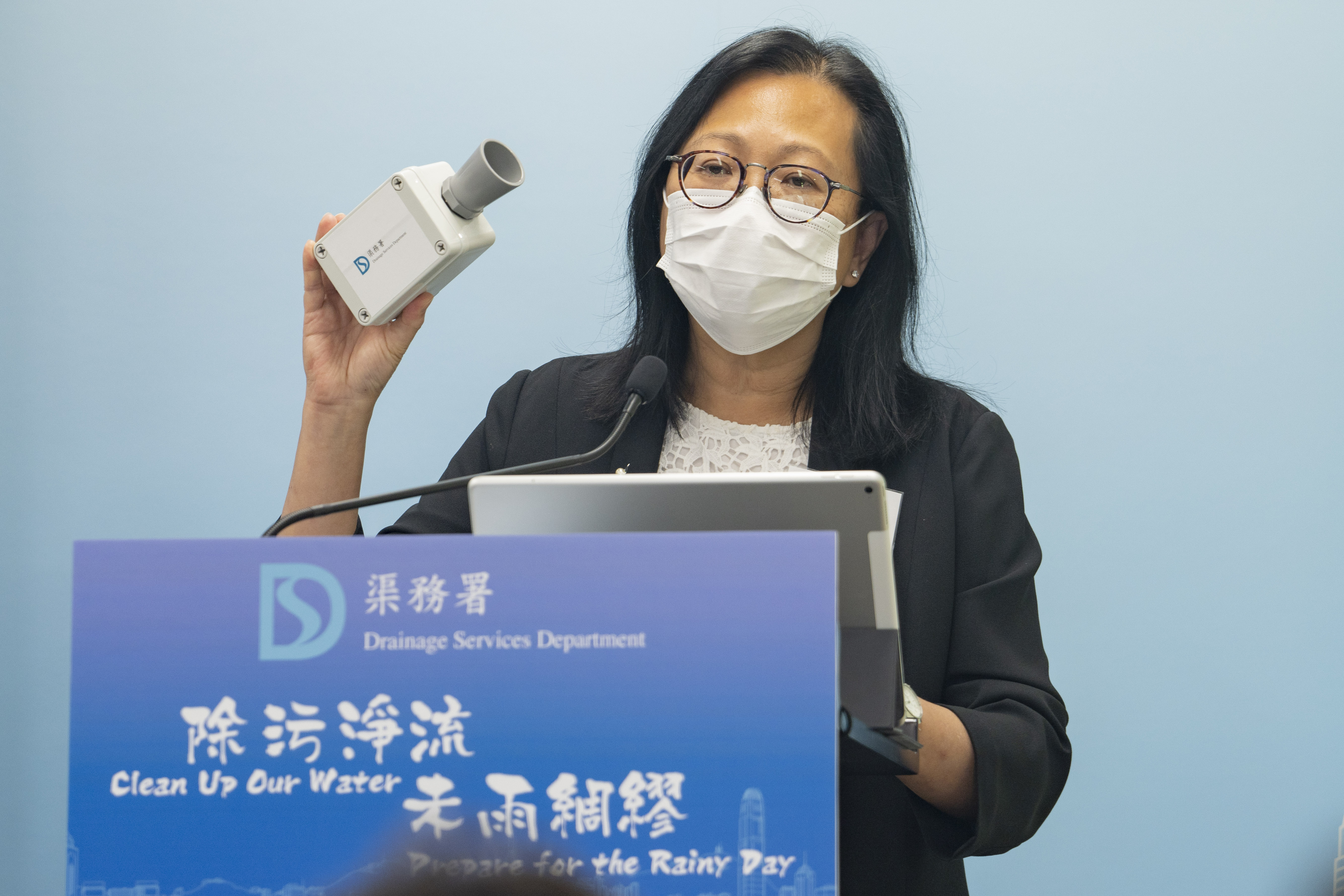 The Director of Drainage Services, Ms Alice PANG, shows the media at the briefing a new model of sensor for installing at drainage channels 