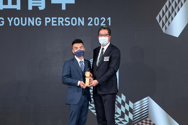 钟智伟先生(左)获选为「2021建造业杰出青年」，发展局局长黄伟纶(右)于颁奖礼颁奖予钟先生