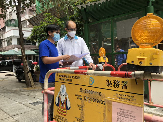 DSD Engineer Mr Michael CHENG Chung-wai (right) inspects the site location with his teammate