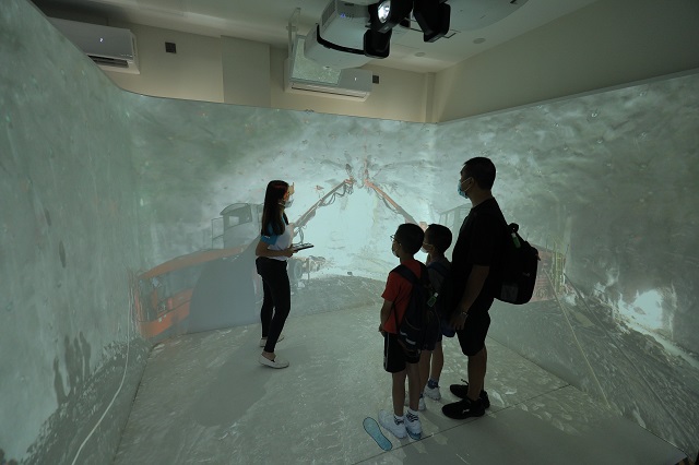 The Drainage Services Department (DSD) holds the Relocation of Sha Tin Sewage Treatment Works to Caverns - Community Liaison Centre Open Day today (August 27) and tomorrow (August 28). Photo shows a visitor of using the Immersive Cave Automatic Virtual Environment System.