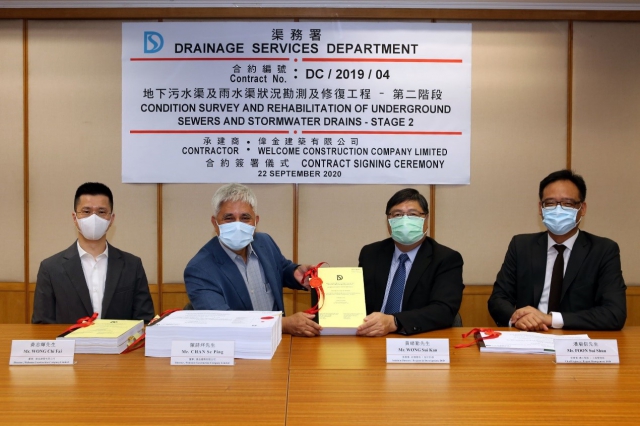 The Assistant Director / Projects and Development of DSD, Mr WONG Sui-kan (second right), and the Director of Welcome Construction Company Limited, Mr CHAN Se-ping (second left), attended the contract signing ceremony